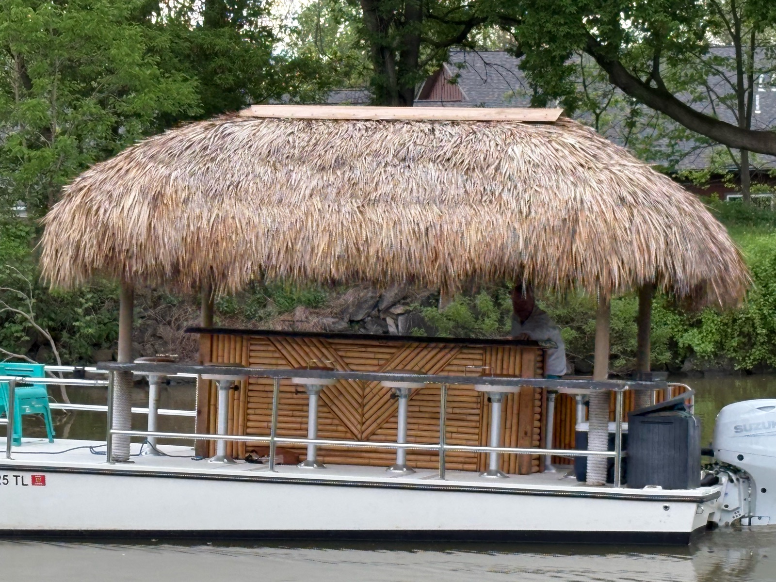 The Tiki Drifters floating tiki bar — a hand-built thatched-roof bamboo bar on a pontoon boat, docked on the Erie Canal in Fairport, NY